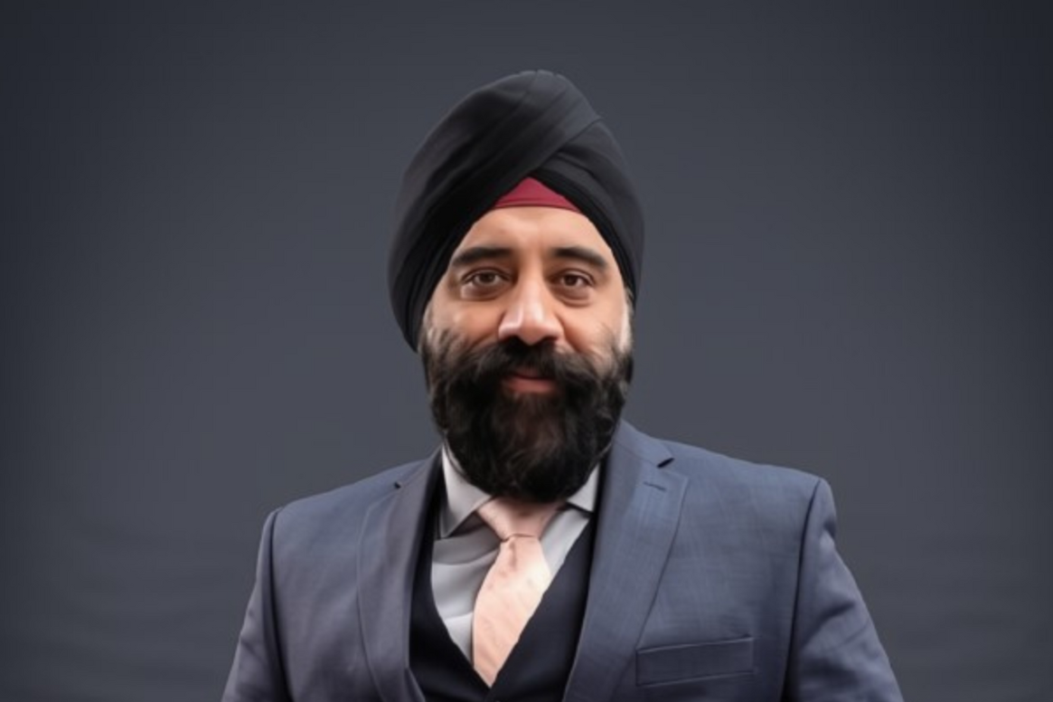 Portrait of a bearded man in a black turban and blue suit against a gray background