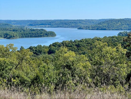 a large body of water surrounded by trees on a sunny day