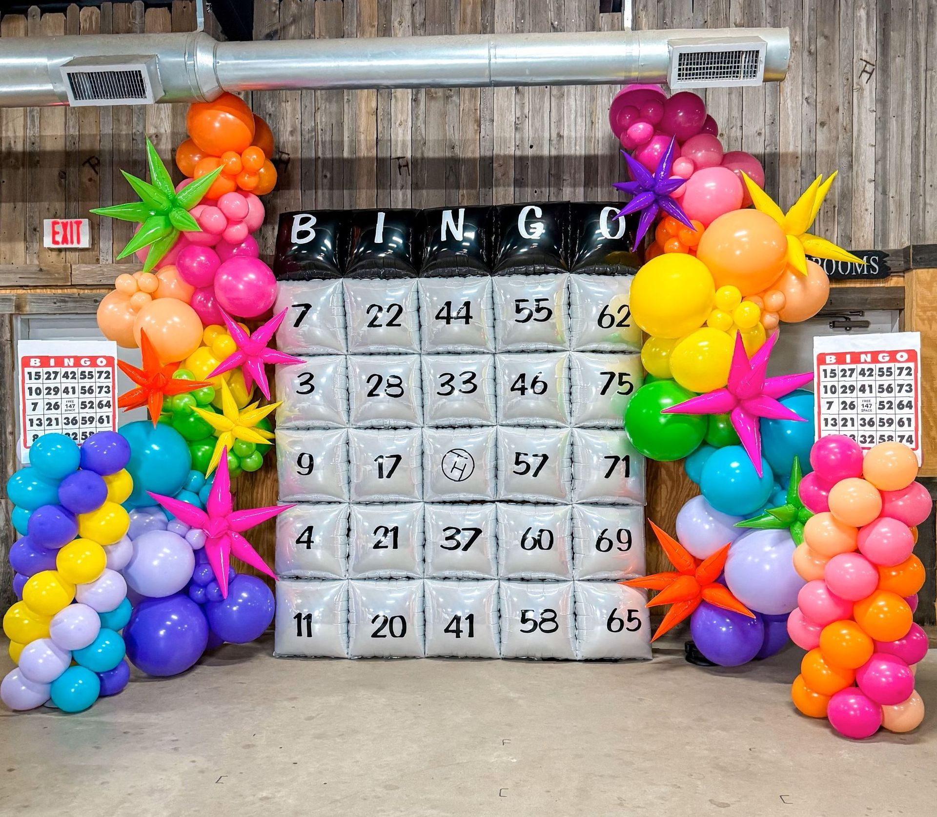 A bingo board is decorated with balloons and stars.
