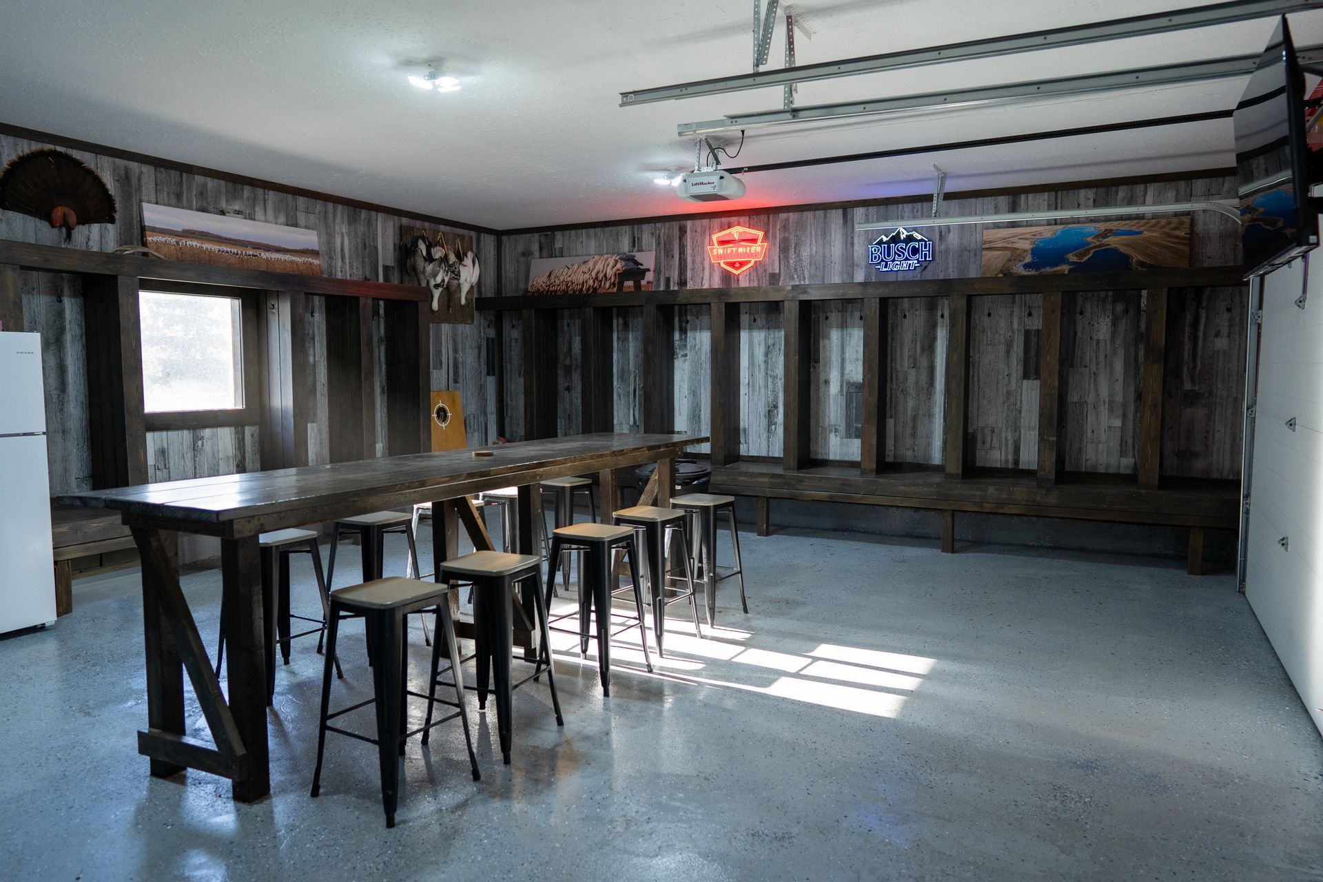 A large room with a long table and stools in it