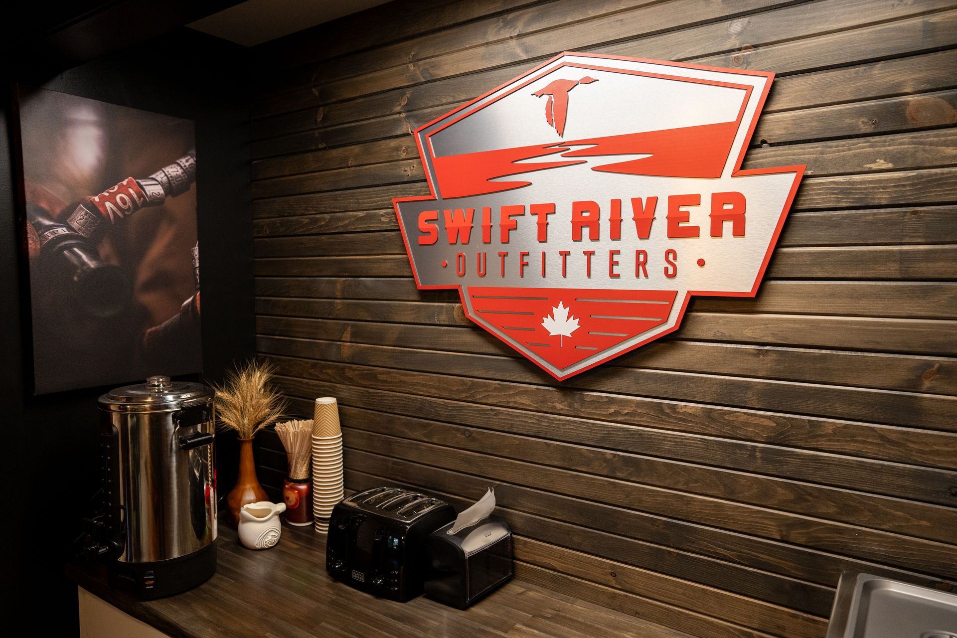 A sign on a wooden wall that says swift river outfitters