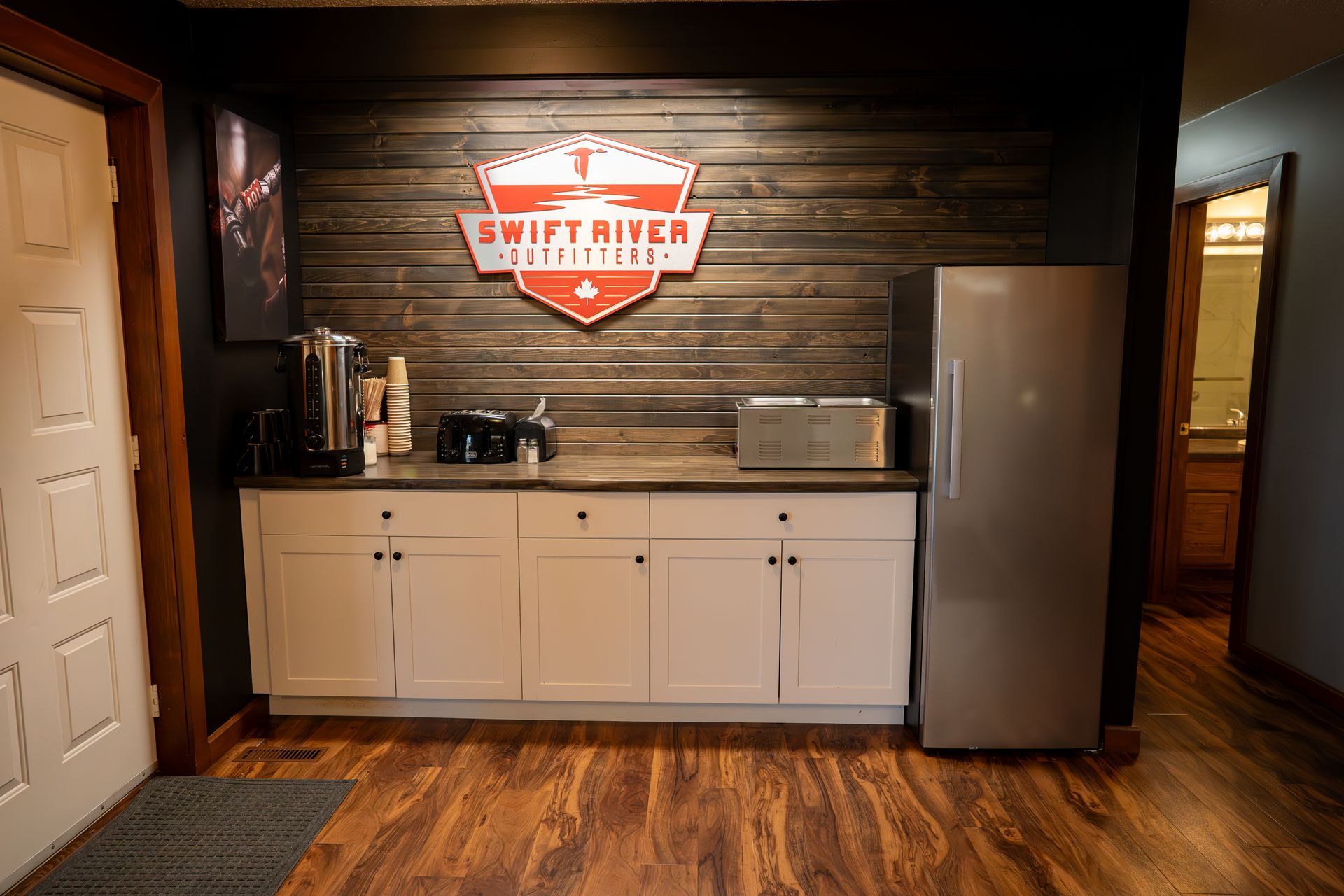 A kitchen with a sign on the wall that says `` swift river ''.
