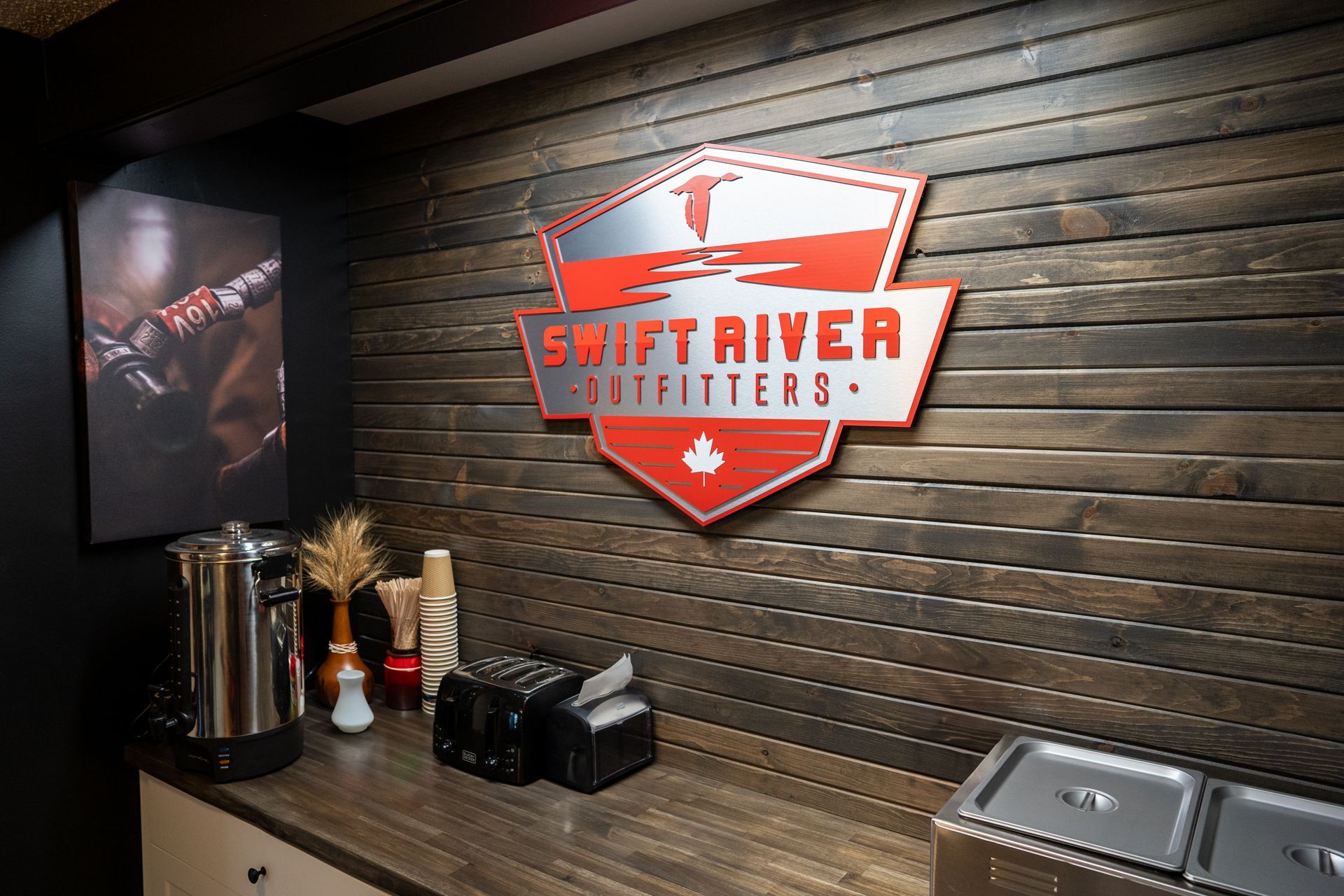 A wooden wall with a sign that says swift river outfitters