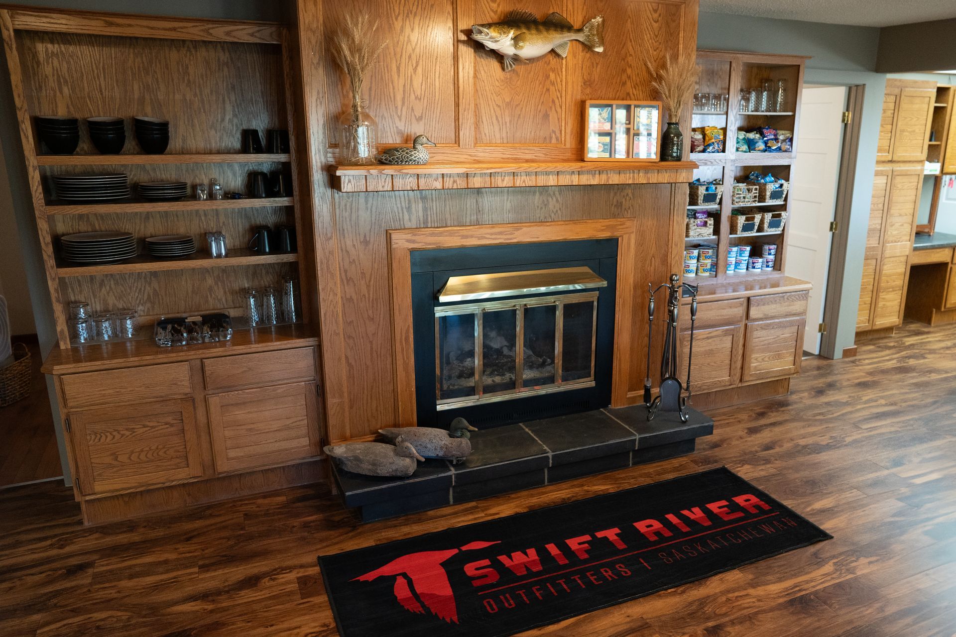 A living room with a fireplace and a rug that says swift river.