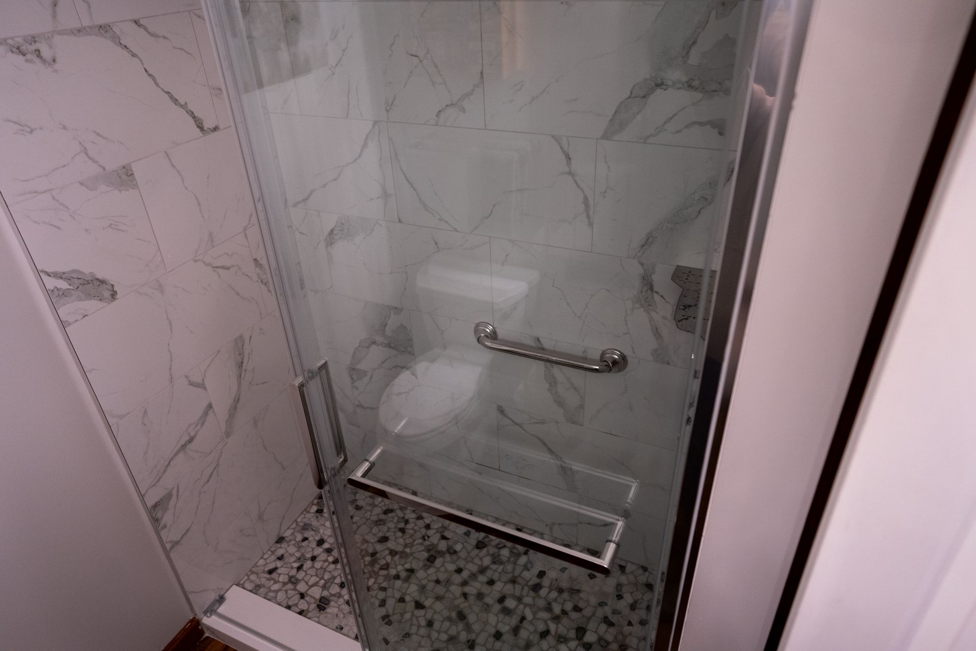 A bathroom with a walk in shower and a toilet.