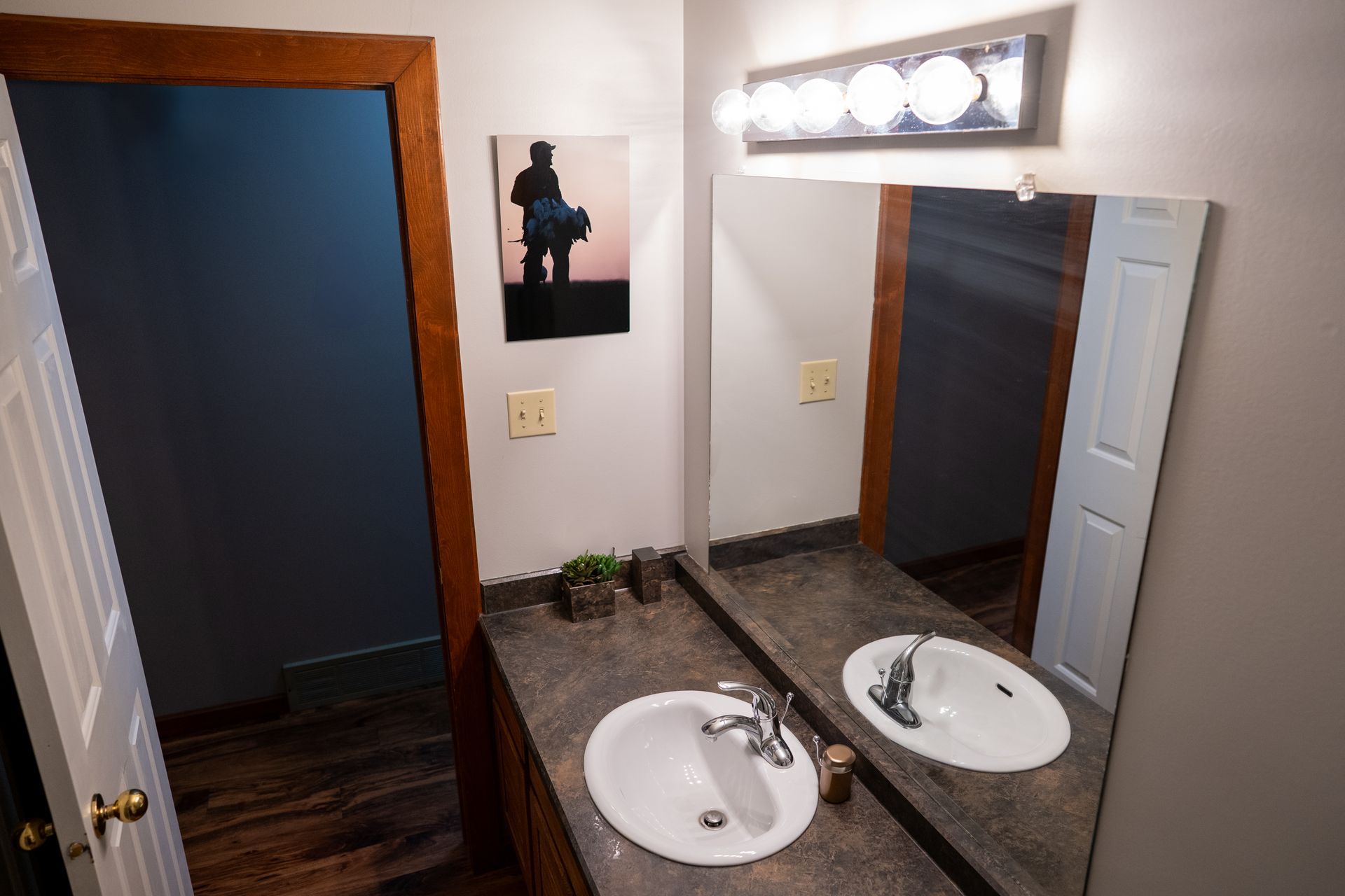 A bathroom with two sinks and a large mirror.