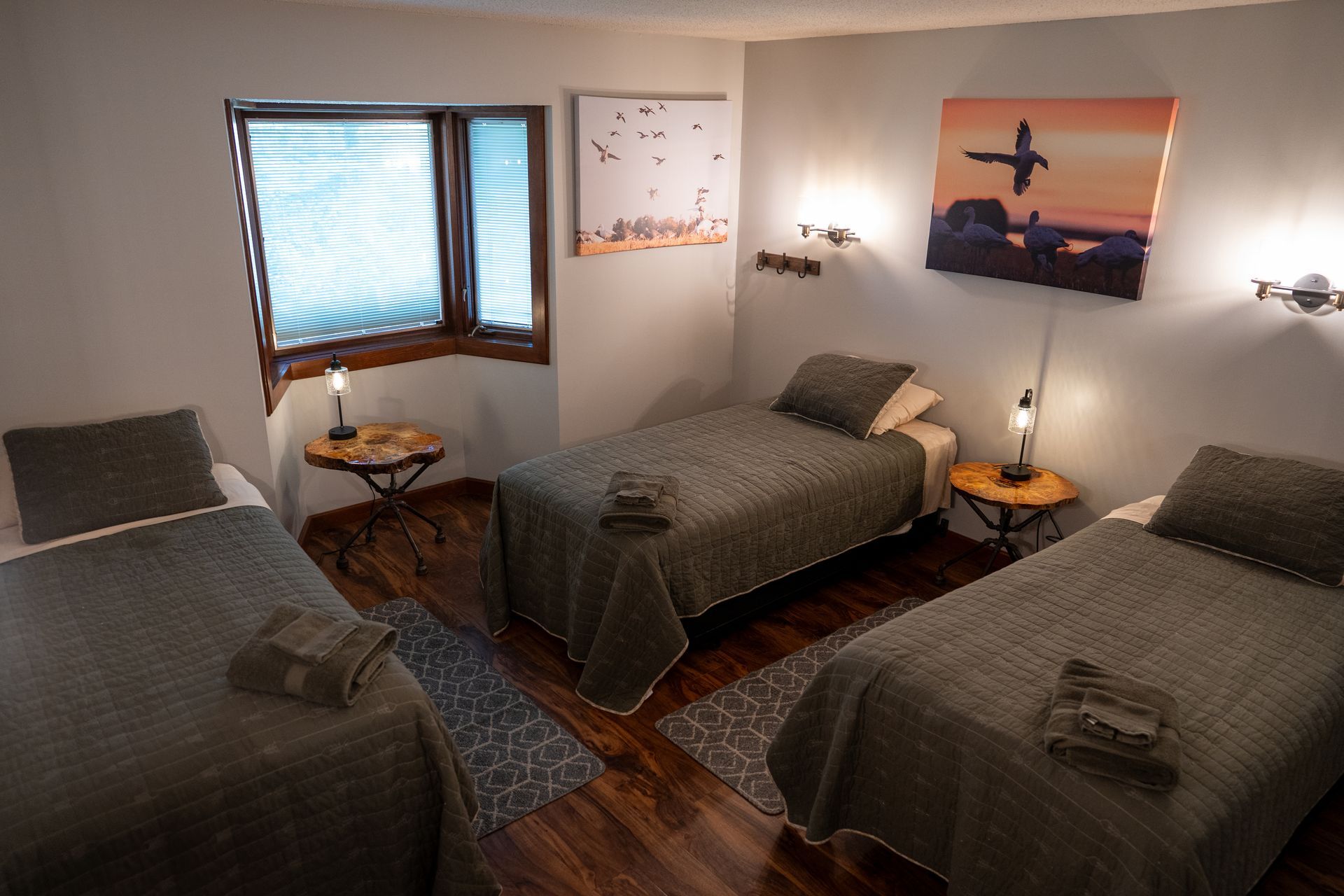 A bedroom with two beds and a painting on the wall