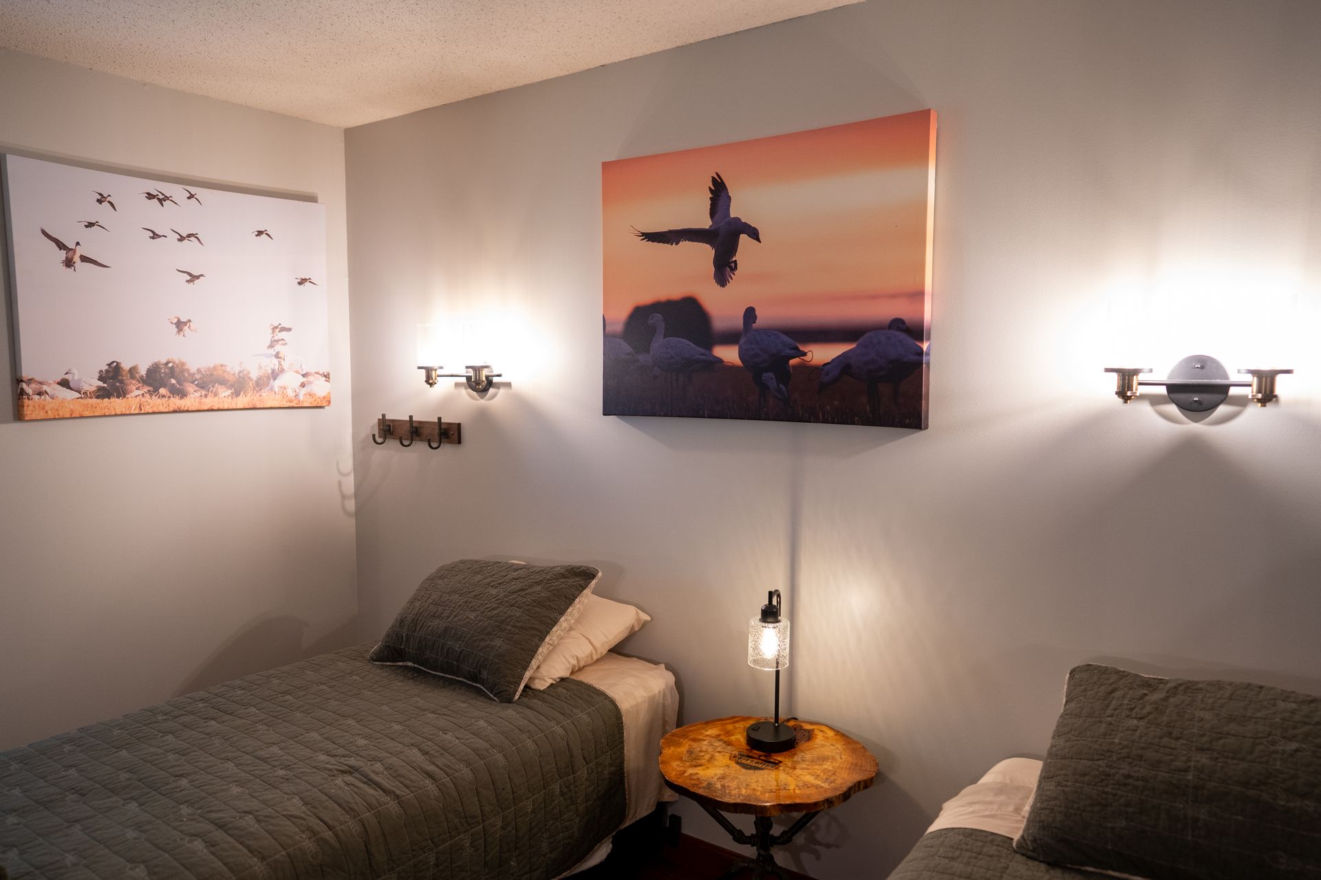 A bedroom with a single bed , two chairs and a painting on the wall.