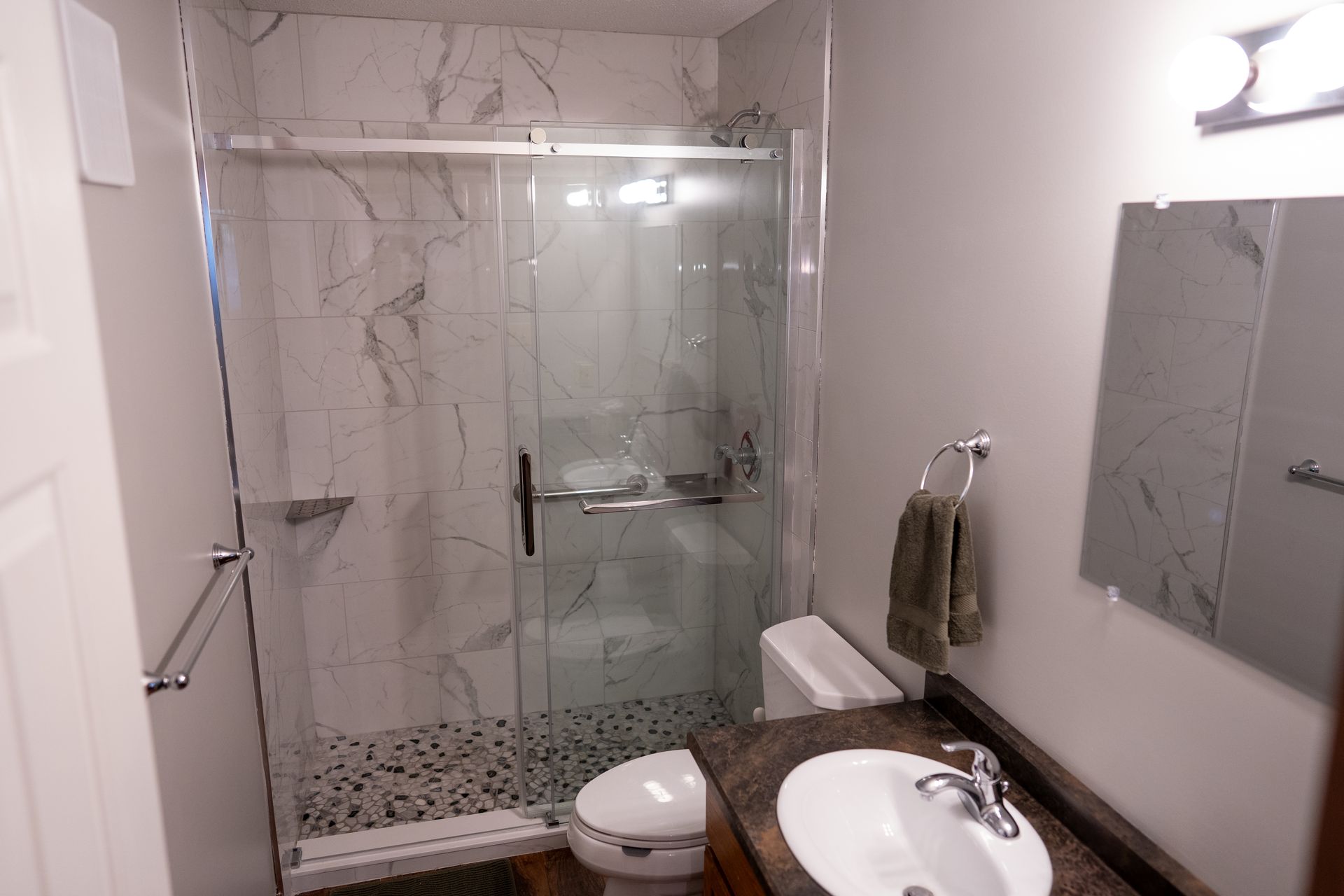 A bathroom with a toilet , sink , and shower.