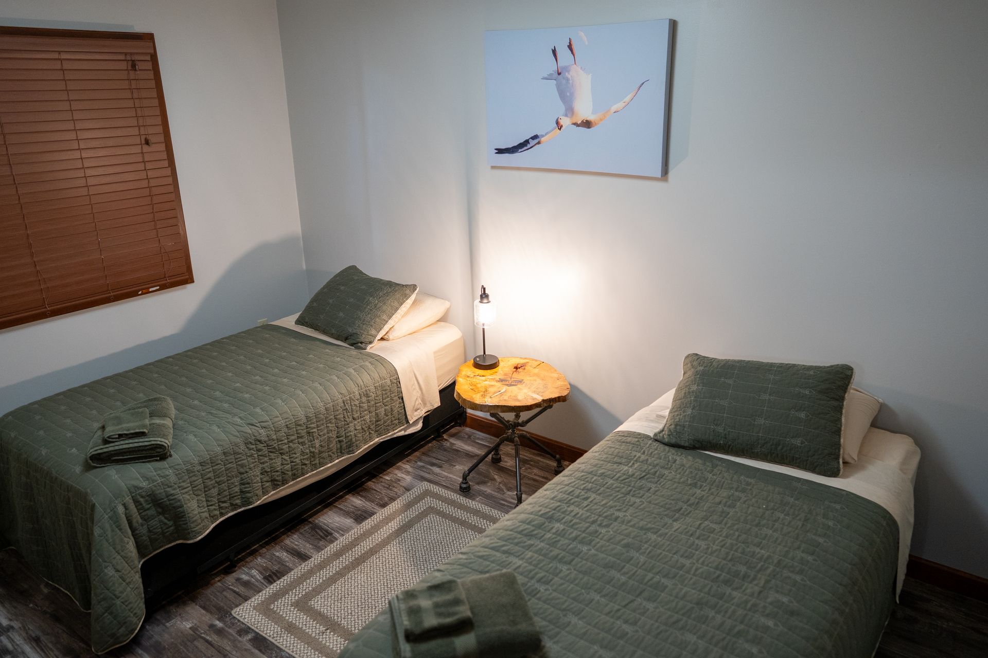 A bedroom with two beds and a painting on the wall.