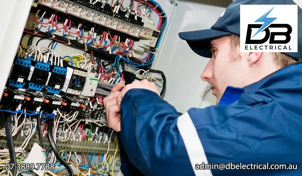 A Man Working On An Electrical Box With DB Electrical In The Background – Brendale, QLD - DB Electrical