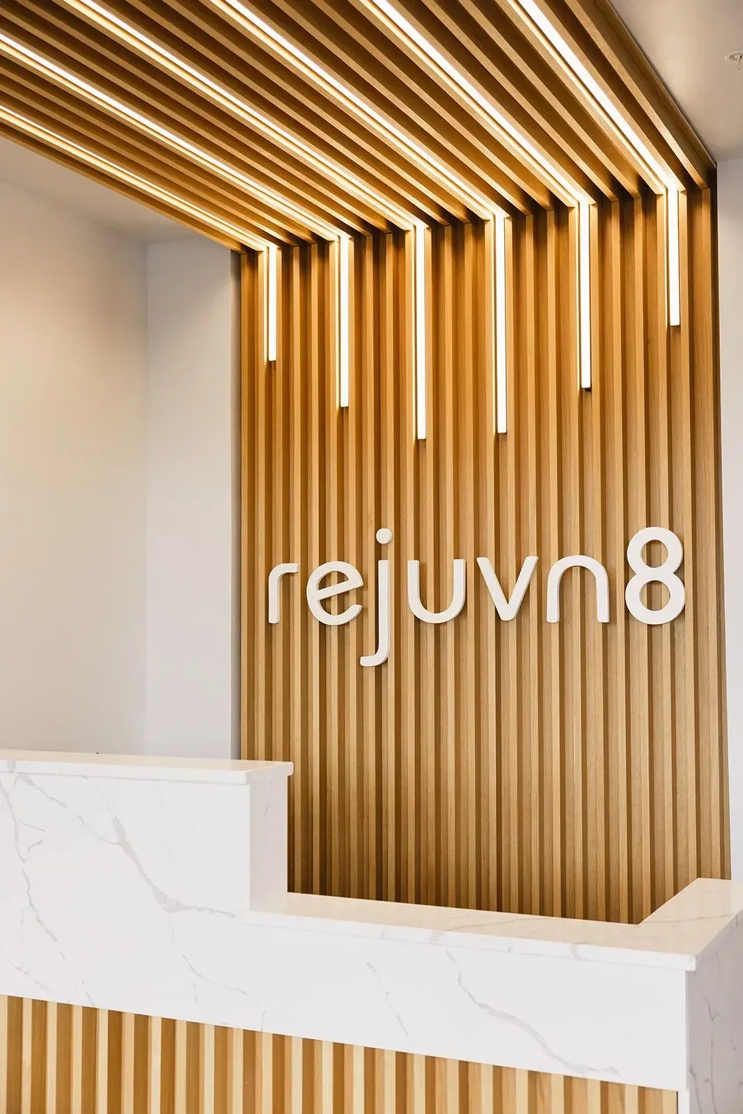 The words Rejuvn8 on a wooden background in their office 