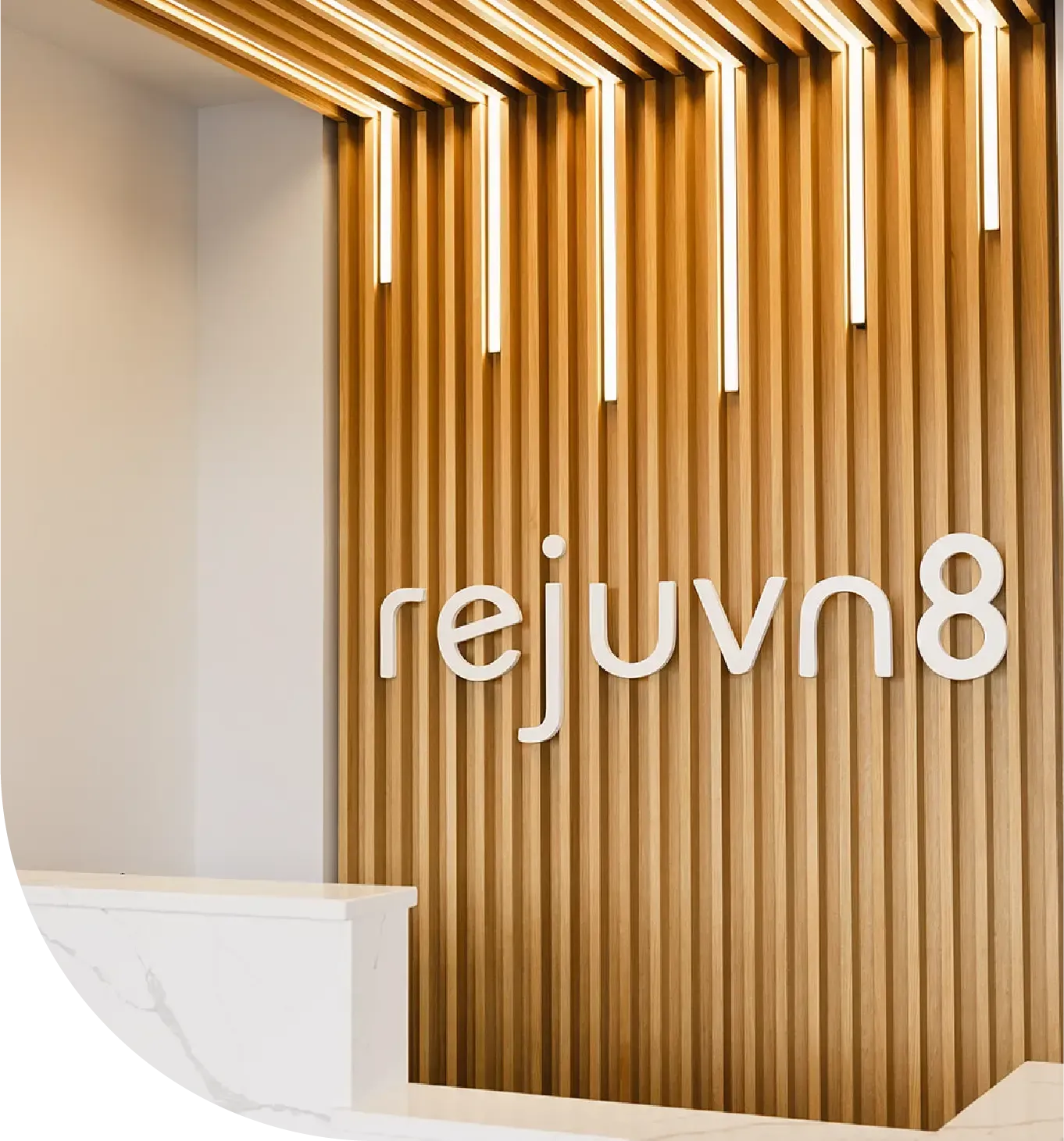 Rejuvn8 logo on wooden pannel. Rejuvn8 Aesthetics med spa in Syracuse, NY, logo on a wooden panel