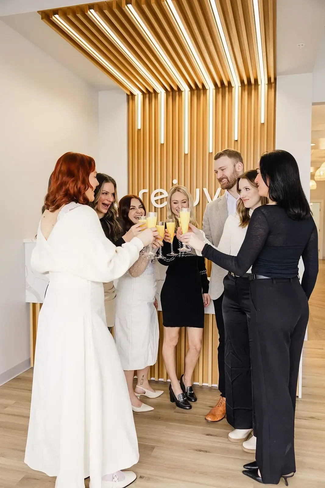 A group of people are toasting with champagne in a room.