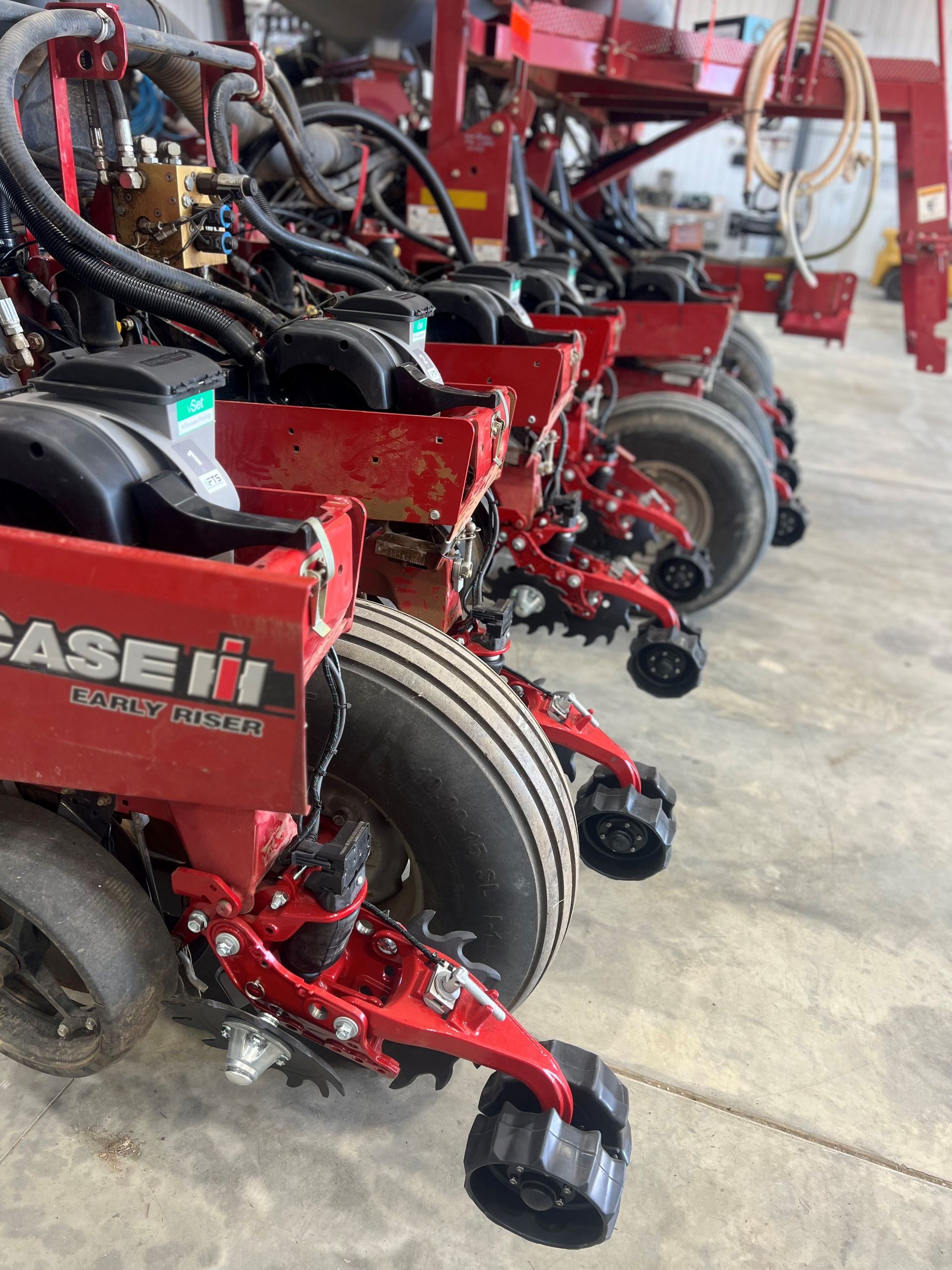A row of case ih tractors are lined up in a garage.