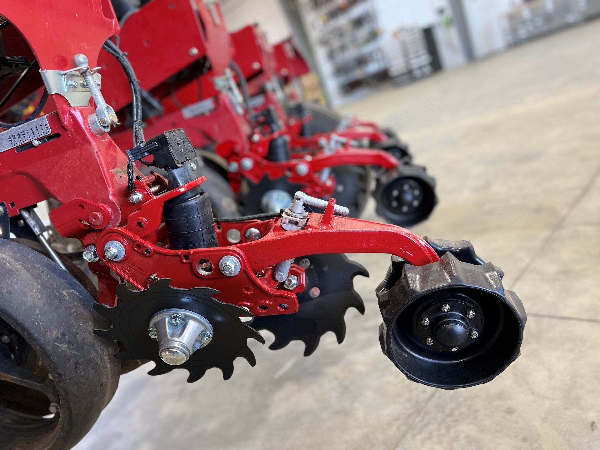 A close up of a row of red tractors in a warehouse.
