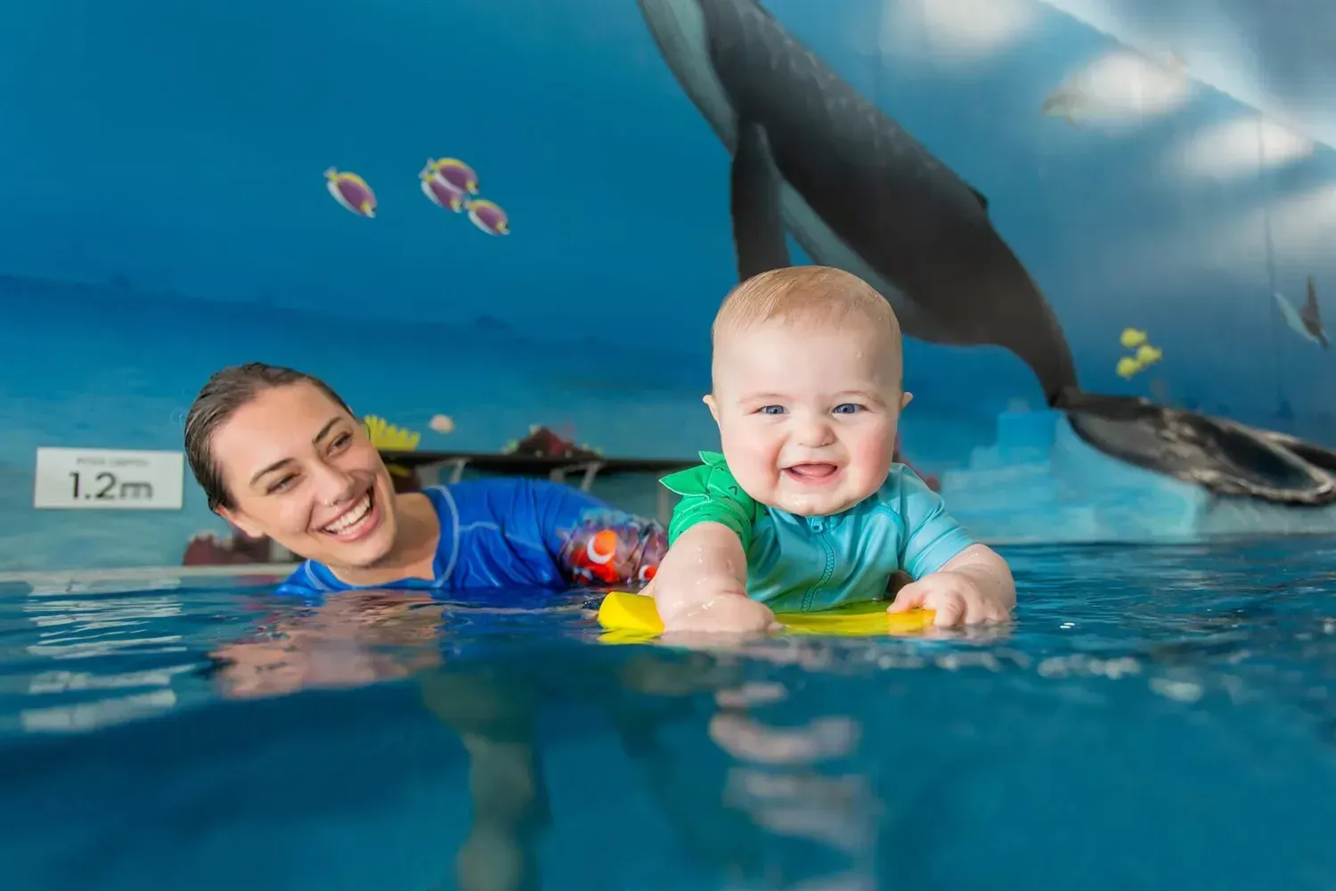 A child is in a swimming pool with instructor while hanging ahold of a floatie — Swim Care Boambee in Coffs Harbour, NSW