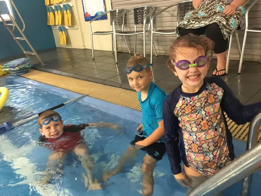 Children wearing goggles during a swim lesson at SwimCare Swim School