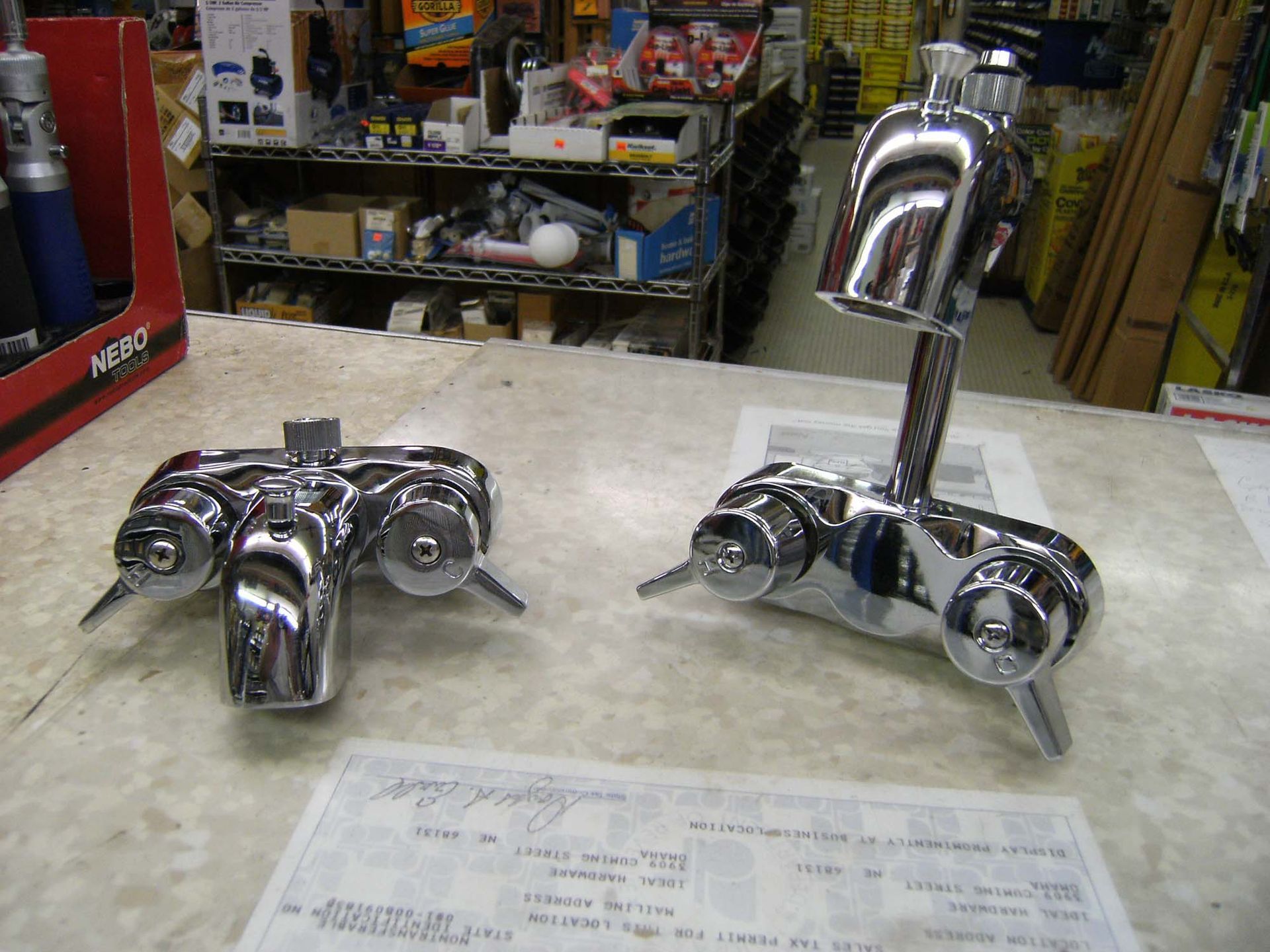 Two chrome faucets are sitting on a counter in a store
