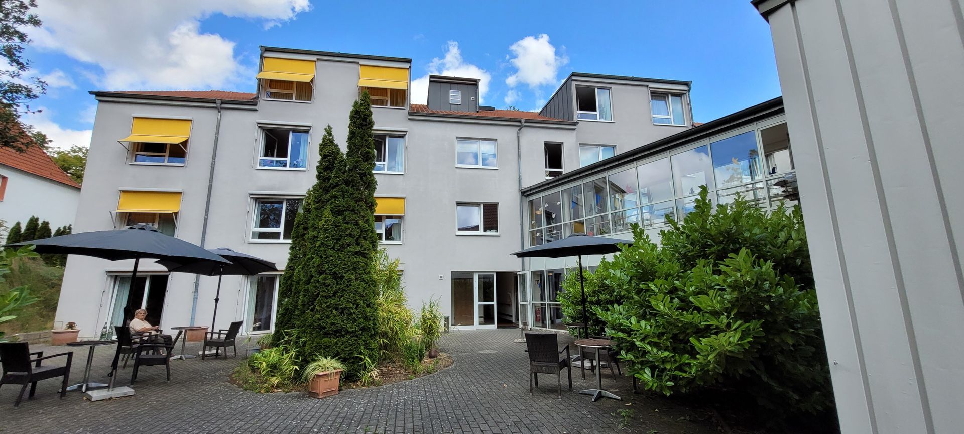 Ein großes Gebäude mit Sonnenschirmen und Stühlen davor
