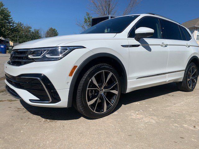 A white volkswagen tiguan is parked on the side of the road.
