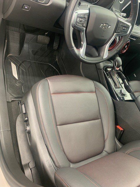 The inside of a car with a steering wheel and seats.