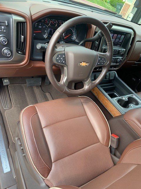 The interior of a chevrolet truck with brown leather seats and a steering wheel