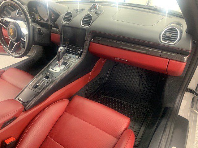The interior of a car with red seats and a steering wheel.