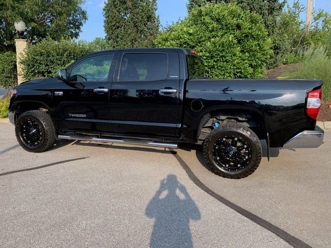 A black toyota tundra truck is parked in a parking lot.