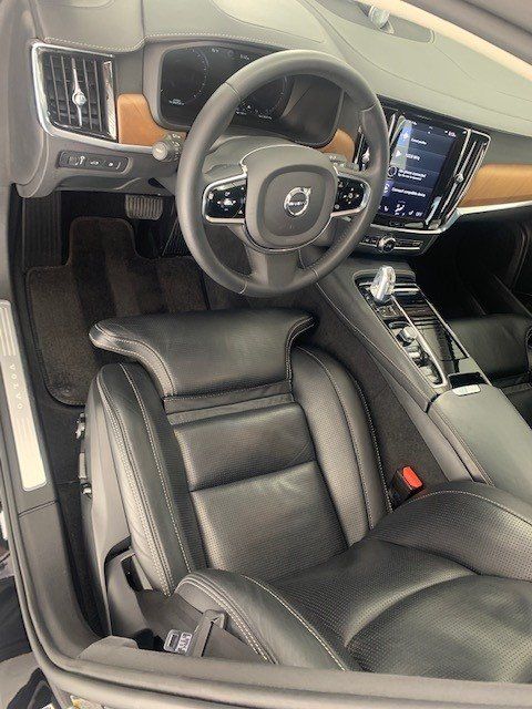 The interior of a volvo car with leather seats and a steering wheel.