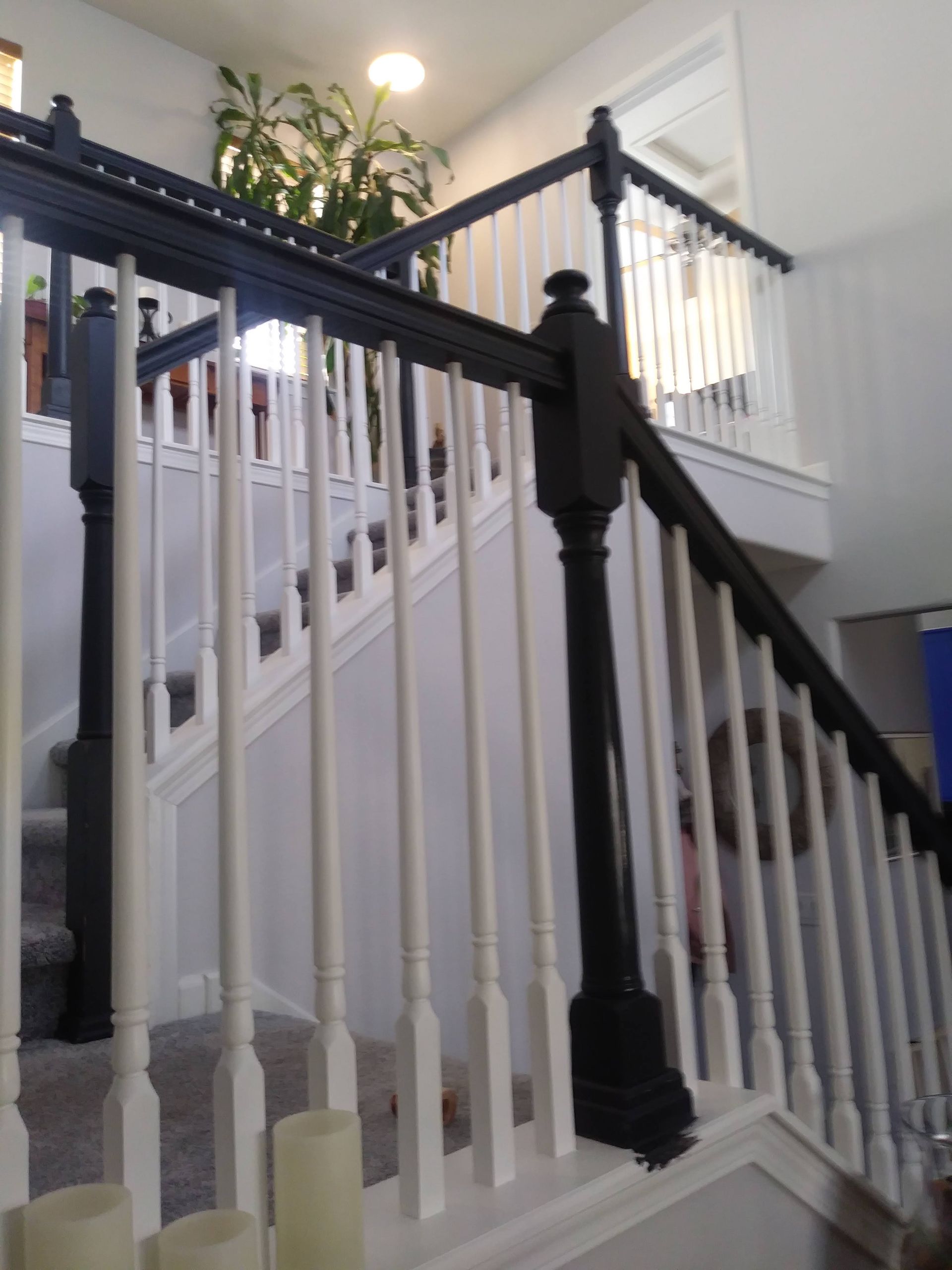 Staircase with white balusters and dark banister in a bright home interior