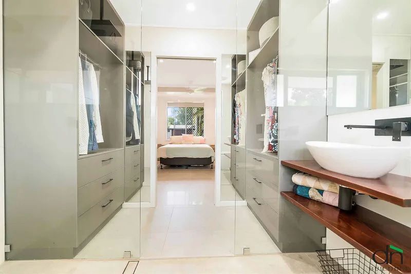 A Bathroom With a Sink and a Walk in Closet Leading to a Bedroom — Custom Cabinets Design in Berrimah, NT