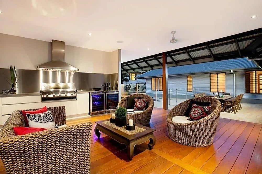 A Living Room With Wicker Furniture and a Table — Custom Cabinets Design in Berrimah, NT