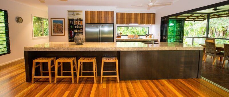 A Kitchen with A Large Island and Stools — Custom Cabinets Design in Berrimah, NT