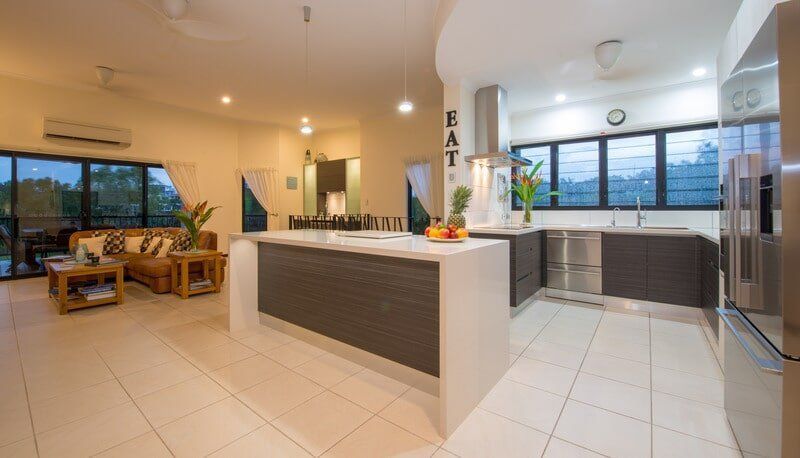 A Kitchen with Stainless Steel Appliances and A Large Island — Custom Cabinets Design in Berrimah, NT