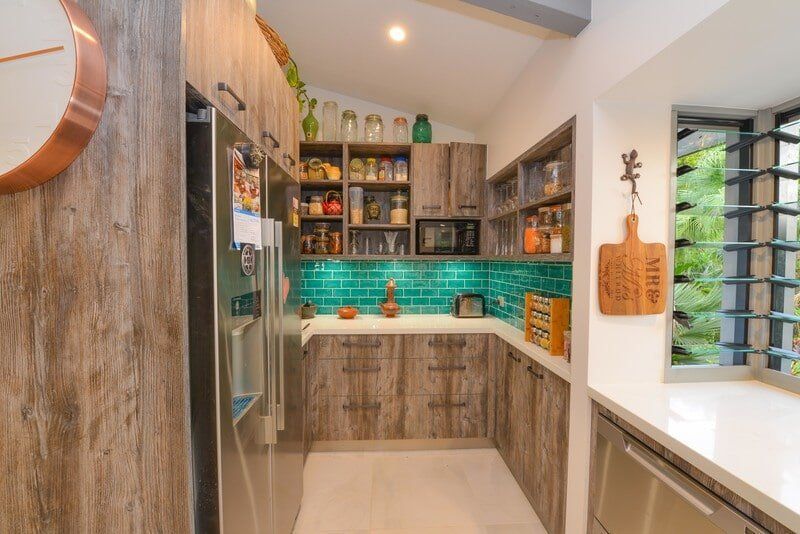A Kitchen with Wooden Cabinets , Stainless Steel Appliances and A Clock on The Wall — Custom Cabinets Design in Berrimah, NT