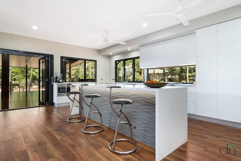A Kitchen with A Large Island and Stools in It — Custom Cabinets Design in Berrimah, NT