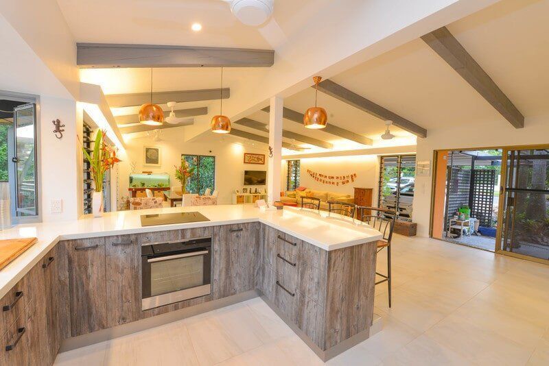 A Kitchen with Wooden Cabinets , Stainless Steel Appliances , and A Large Island — Custom Cabinets Design in Berrimah, NT