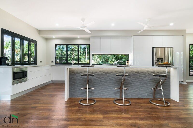 A Kitchen with A Large Island and Stools and A Ceiling Fan — Custom Cabinets Design in Berrimah, NT