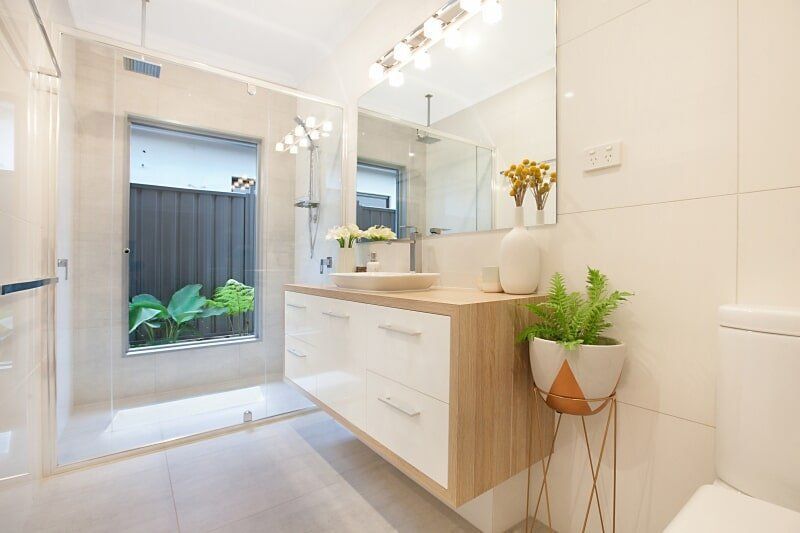 A Bathroom with A Sink, Toilet, Mirror and Walk in Shower — Custom Cabinets Design in Berrimah, NT