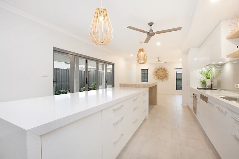 A Kitchen with White Cabinets and A Ceiling Fan — Custom Cabinets Design in Berrimah, NT