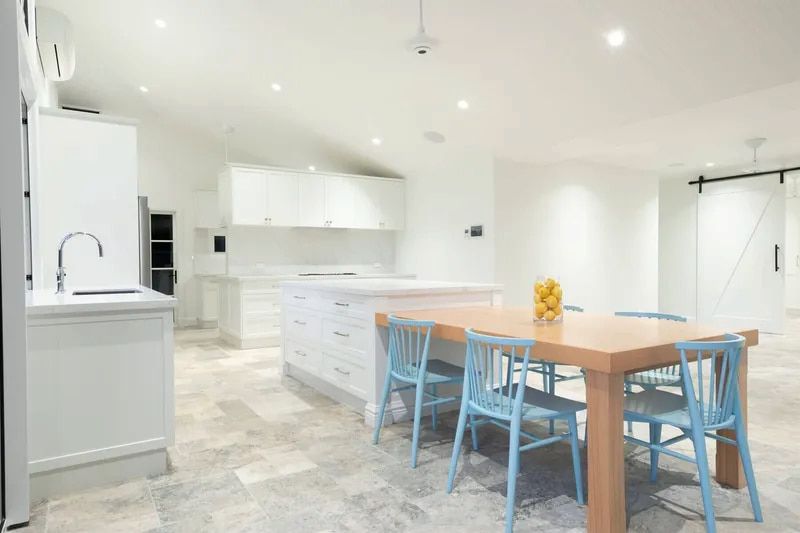 A Kitchen With a Wooden Table and Blue Chairs — Custom Cabinets Design in Berrimah, NT