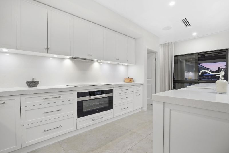 A Kitchen With White Cabinets, a Stove, a Microwave and a Television — Custom Cabinets Design in Berrimah, NT