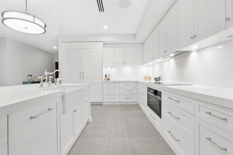 A Kitchen With White Cabinets, Counter Tops, and Appliances — Custom Cabinets Design in Berrimah, NT