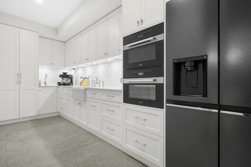 A Kitchen With White Cabinets, Black Appliances and a Black Refrigerator — Custom Cabinets Design in Berrimah, NT