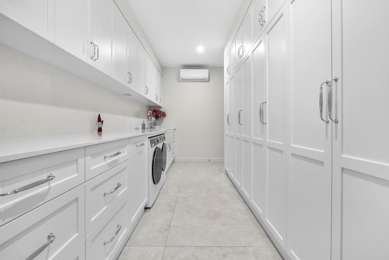 A Laundry Room White Cabinetry and Tiled Floors — Custom Cabinets Design in Fannie Bay, NT