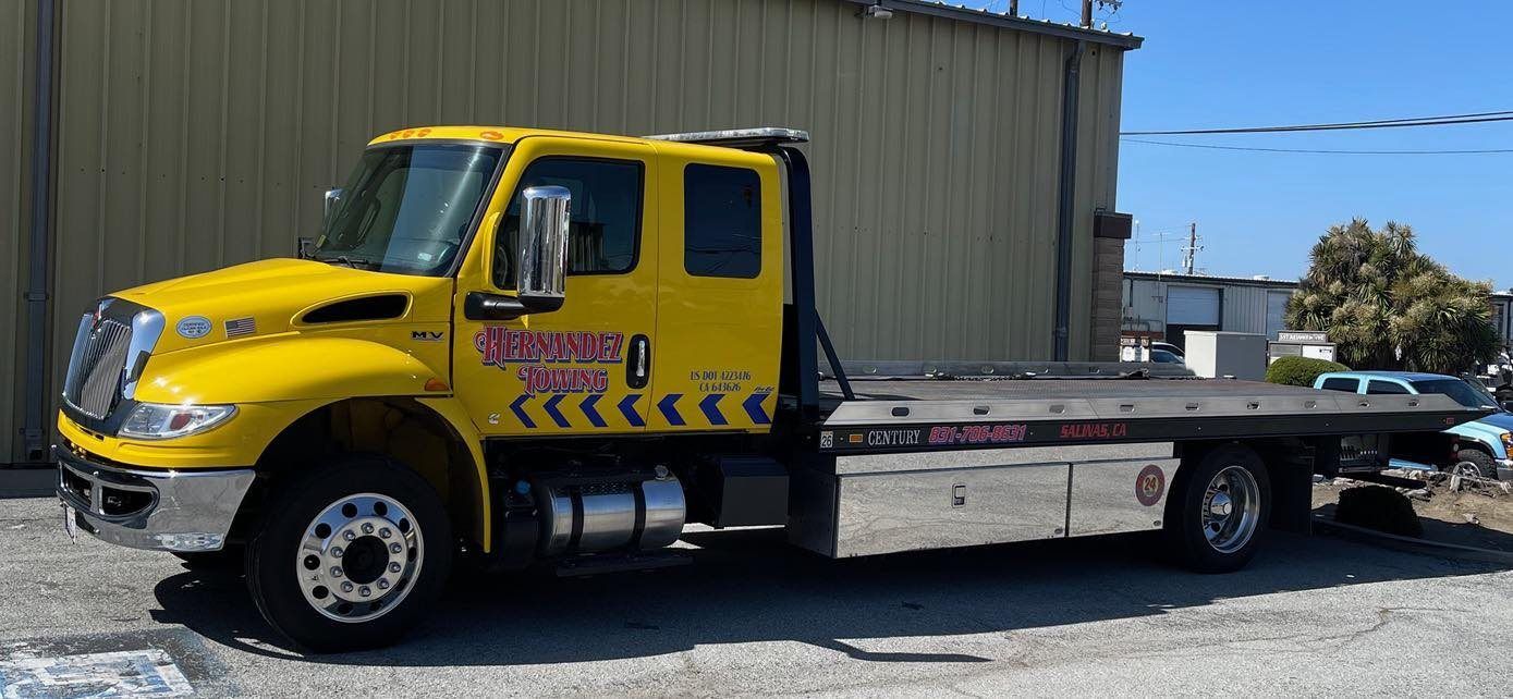 Yellow tow truck parked outside a building on a sunny day. Yellow tow truck parked outside a building on a sunny day.