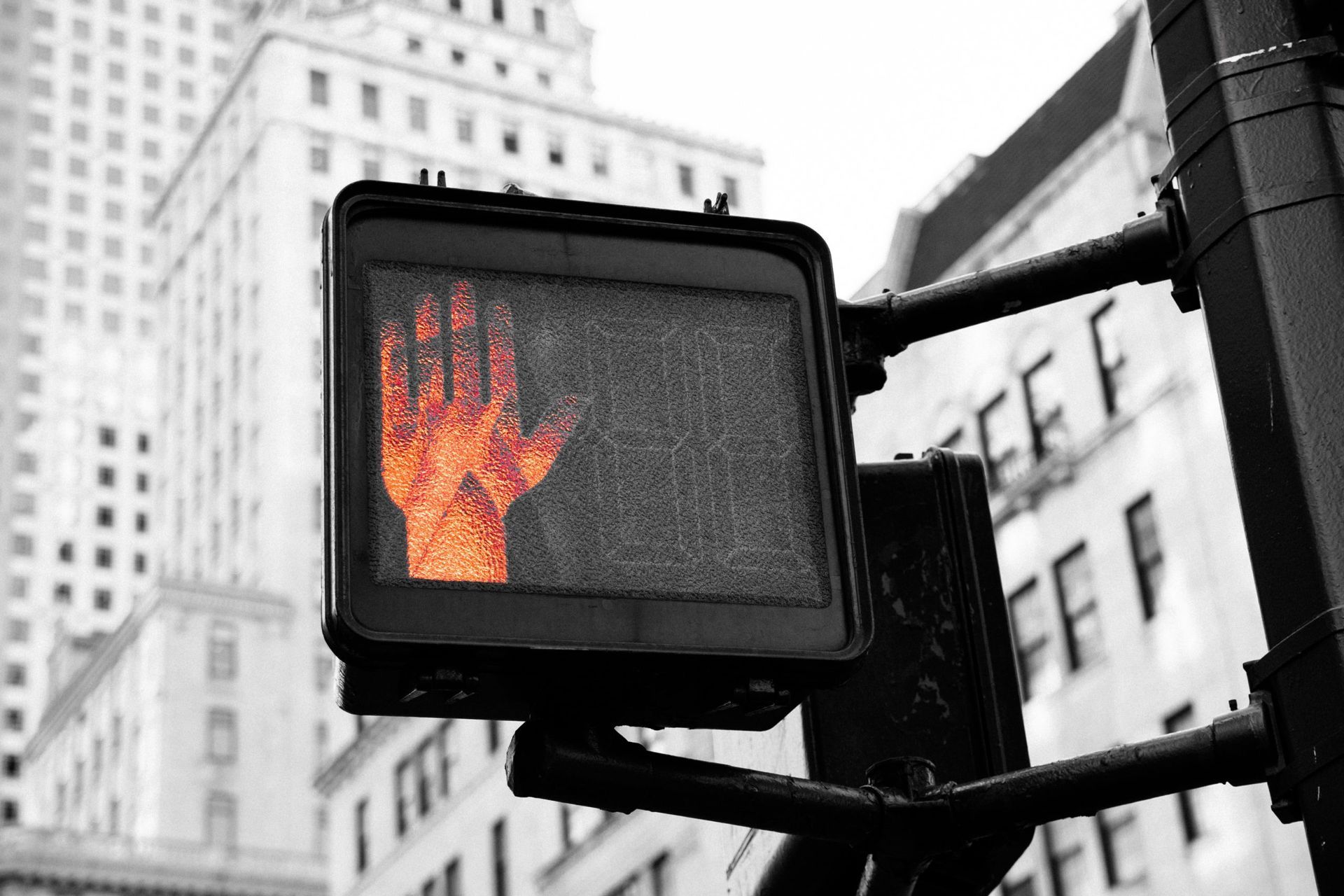 Een stopbord met een oranje hand erop