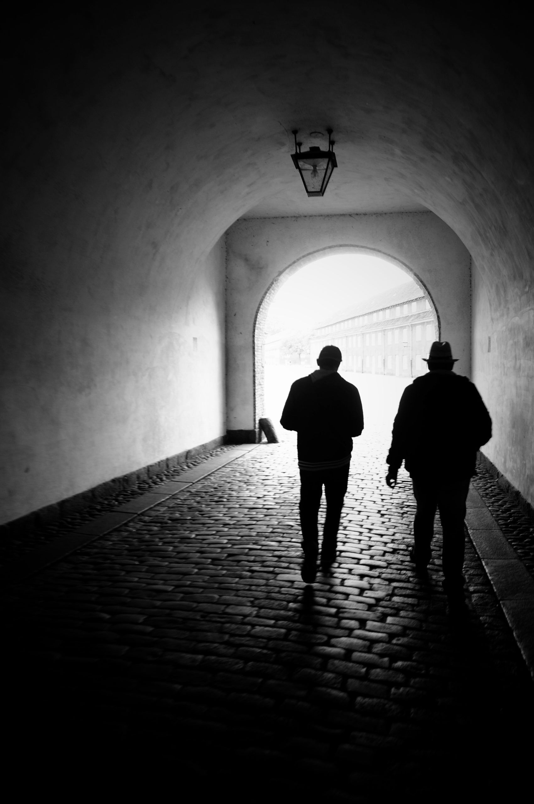 twee mannen lopen door een tunnel.
