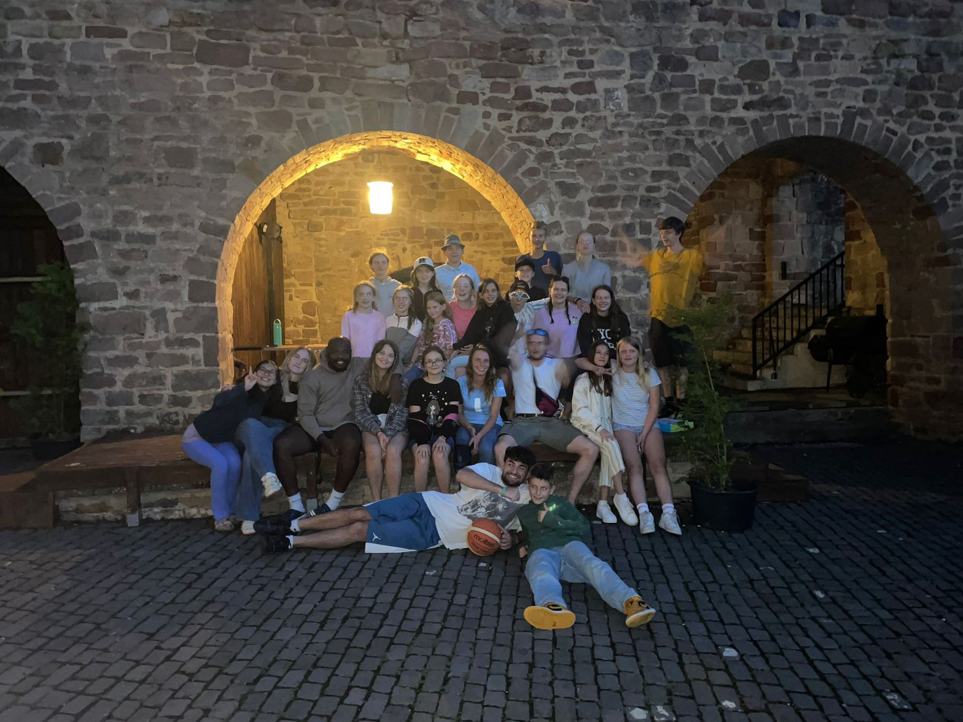 Eine Gruppe von Menschen posiert vor einem Backsteingebäude für ein Foto.